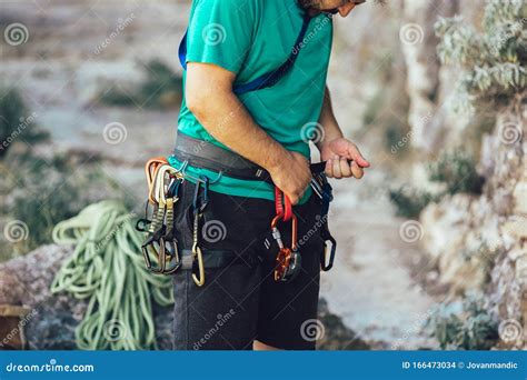 Climber with Climbing Equipment, Tying Knot on Climbing Harness ...