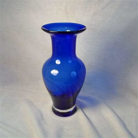 A Blue Vase Sitting On Top Of A White Sheet