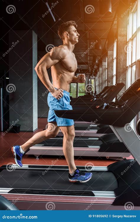 Homem Adulto Novo Que Corre Na Escada Rolante No Gym Foto De Stock