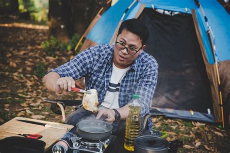 Premium Photo Man On Camping Holiday Frying Egg In Pan