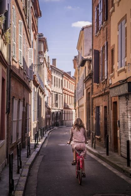 Tiro Vertical De Uma Mulher Andando De Bicicleta Nas Ruas De Toulouse