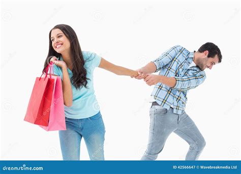 Homem Novo Atrativo Que Puxa Sua Amiga Shopaholic Imagem De Stock