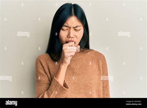 Young Chinese Woman Wearing Casual Clothes Feeling Unwell And Coughing