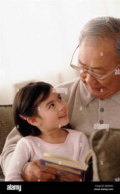 Grandfather Reading To Granddaughter Stock Photo Alamy