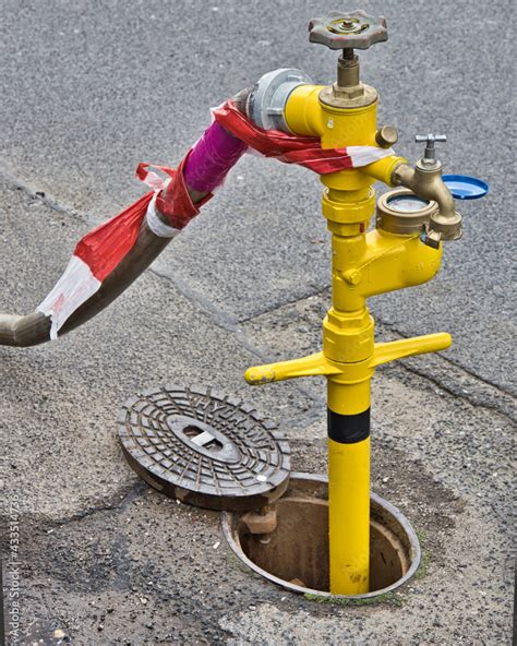 Foto De Der Hydrant Auf Der Strasse Wird Zum Wasser Zapfen Genommen Do Stock Adobe Stock