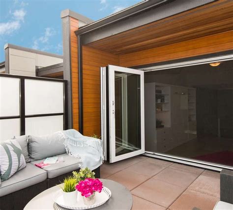 an outdoor living area with couches, table and sliding glass doors