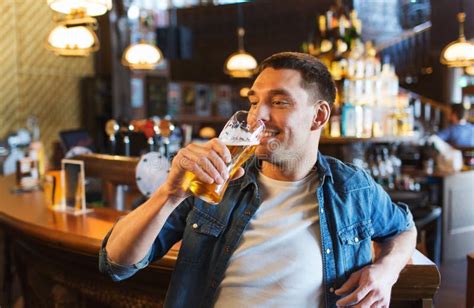 Cerveja Bebendo Do Homem Feliz Na Barra Ou No Bar Foto De Stock