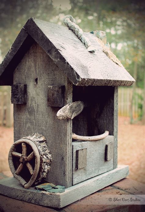 A Wooden Birdhouse With Wheels Attached To It