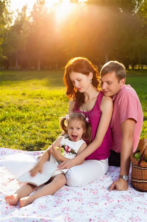 Familia Joven Feliz Que Tiene Comida Campestre En El Prado Foto De