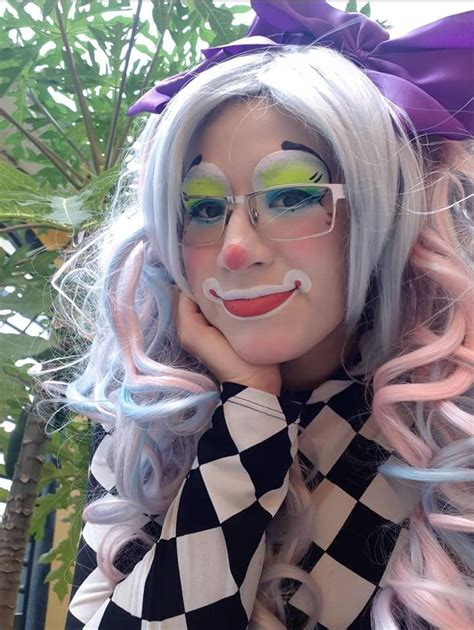 A Woman With White Hair And Green Eyes Wearing A Clown Makeup On Her