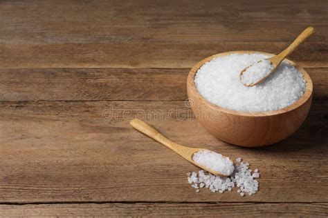 Spoons And Bowl Of Natural Sea Salt On Wooden Table Space For Text