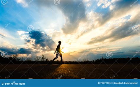 Homem Da Silhueta Que Movimenta Se No Fundo Do Por Do Sol Imagem De