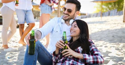 Cerveja Bebendo Dos Pares Novos Felizes E Divertimento Ter Na Praia