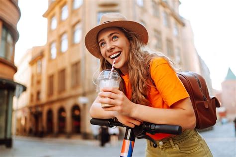 Mulher de férias se divertindo dirigindo scooter elétrico pela cidade