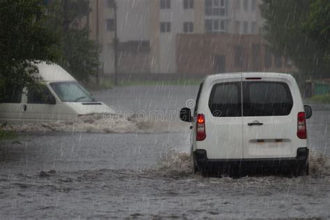 Red Car Rides In Heavy Rain On A Flooded Road Stock Photo Image Of