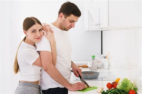 Femme étreignant Son Petit Ami Pendant La Cuisson Photo Gratuite