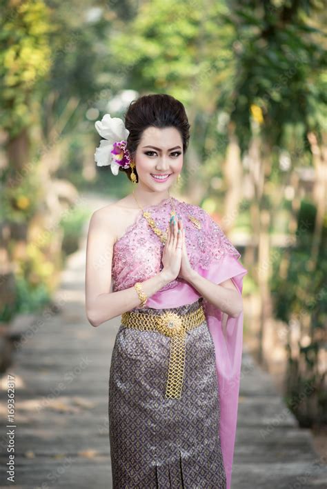 Beautiful Thai girl in Thai traditional costume in Thai's greeting gesture Stock Photo | Adobe Stock