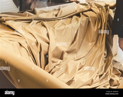 Working With The Golden Satin Fabric Stock Photo Alamy