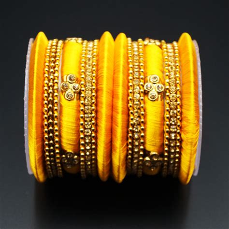 A Stunning Bangle Set Made Up With Gold Diamantes And Yellow Silk