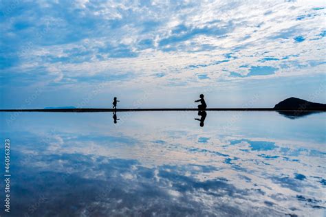 日本のウユニ塩湖と呼ばれている香川県の父母ヶ浜で撮影した人物のシルエット写真 Stock Foto Adobe Stock