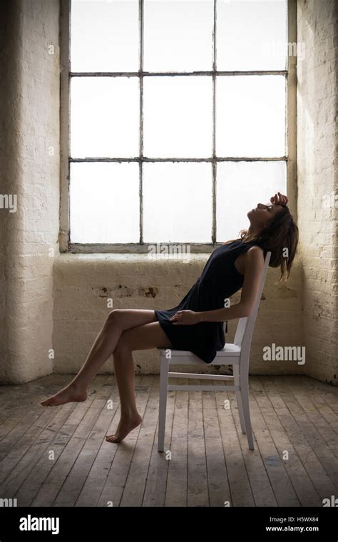 Jeune Fille Assise Sur Une Chaise Banque De Photographies Et Dimages à