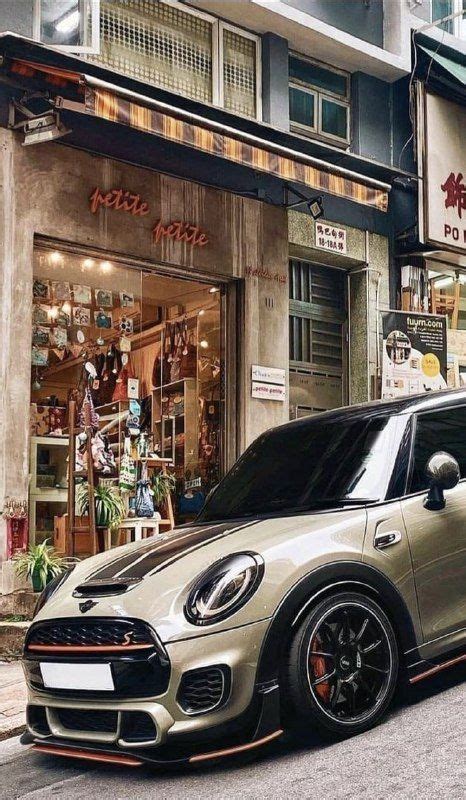 A Mini Cooper Is Parked In Front Of A Store On The Side Of The Road