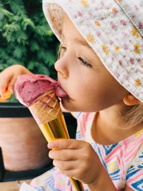 La Petite Fille L Che Un Popsicle Dans Un C Ne Le Tenant Dans Sa Main