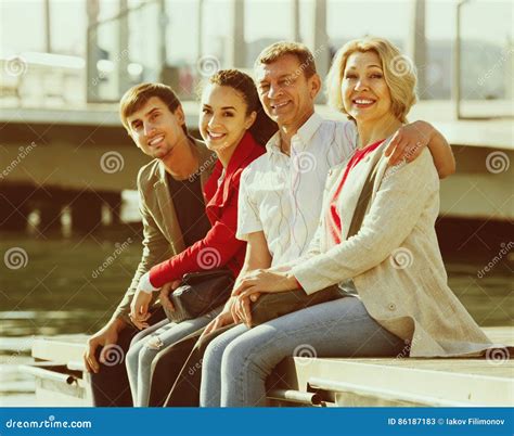Ritratto Di Giovani E Coppie Mature Che Si Siedono Sulla Passeggiata Immagine Stock Immagine