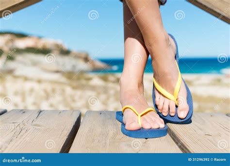 Woman Wearing Flip Flops While Standing On Board Walk Stock Photo