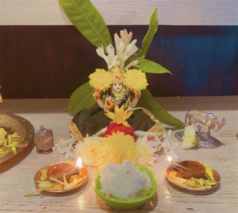 There Is A Small Buddha Statue Surrounded By Flowers And Other Items On