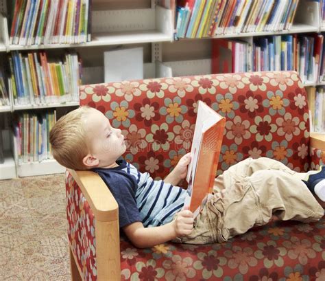 Kind Das Ein Buch Auf Einer Couch An Der Bibliothek Liest Stockfoto