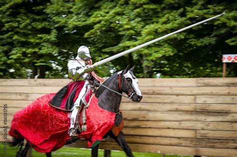 Armored Knight On Horseback Charging In A Joust With The Lance Raised