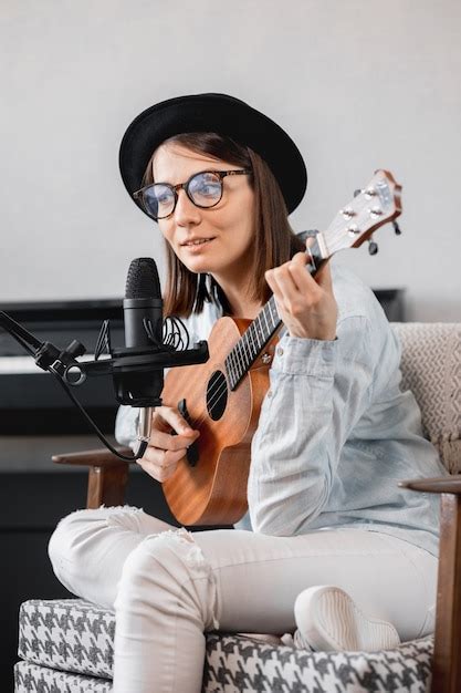 Mujer milenaria caucásica en un sombrero con un micrófono tocando la