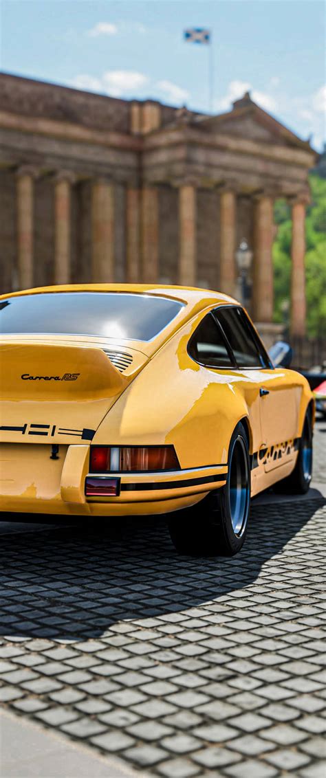 Download Yellow Porsche 911 Parked Outside Wallpaper | Wallpapers.com