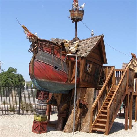 a wooden pirate ship playground with stairs leading up to it