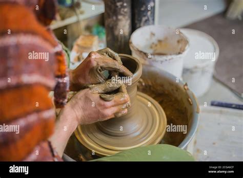 alfarero macho profesional en la rueda de cerámica en el taller