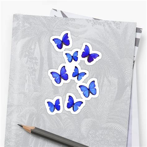 Blue Butterflies Stickers Sitting On Top Of A Piece Of Paper Next To A