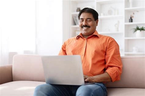 Premium Photo Cheerful Middle Aged Indian Man Using Computer Lapotp