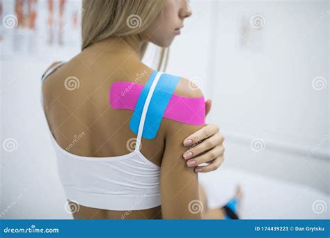 Kinesiology Taping Treatment With Blue And Pink Tape On Female Patient