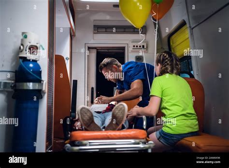 Paramedic In Medical Uniform Puts Oxygen Mask On Woman Liyng On