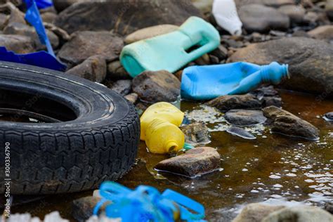 Enviromental Pollution Rubber Tire With Plastic Waste In Dirty Water