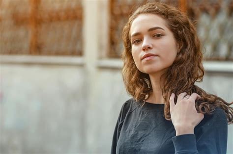 Premium Photo Portrait Nice Girl With Curly Hair In Dark Jacket On Background Of Abandoned