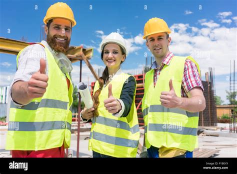 Three Colleagues In A Construction Team Showing Thumbs Up Stock Photo