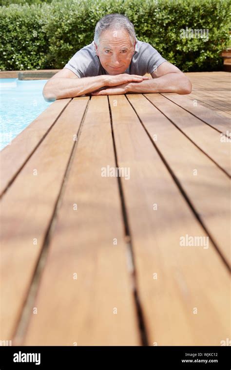 Portrait Of Happy Middle Aged Man Lying By Poolside Stock Photo Alamy