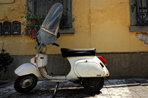 Premium Photo Motor Scooter Parked Against House