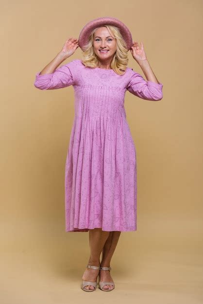 Free Photo Smiley Senior Woman Posing In A Pink Dress