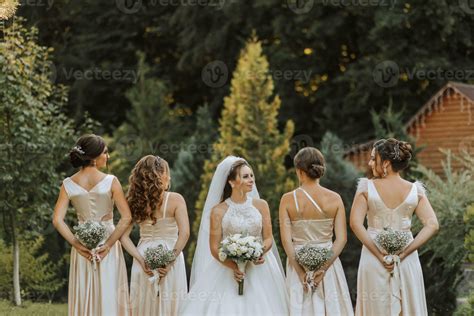 A group of beautiful women in matching dresses are smiling, celebrating, and having fun together ...