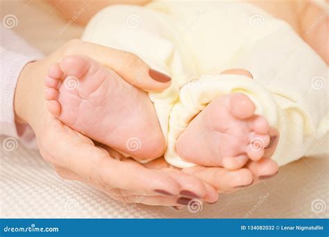 Hand Of Sleeping Baby In The Hand Of Mother Close Up On The Bed Stock