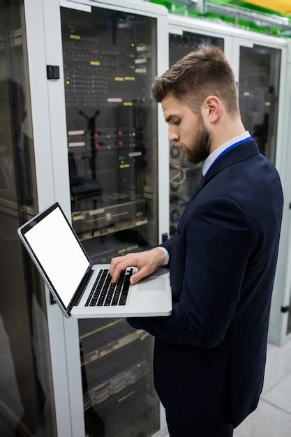 Premium Photo Technician Using Laptop While Analyzing Server